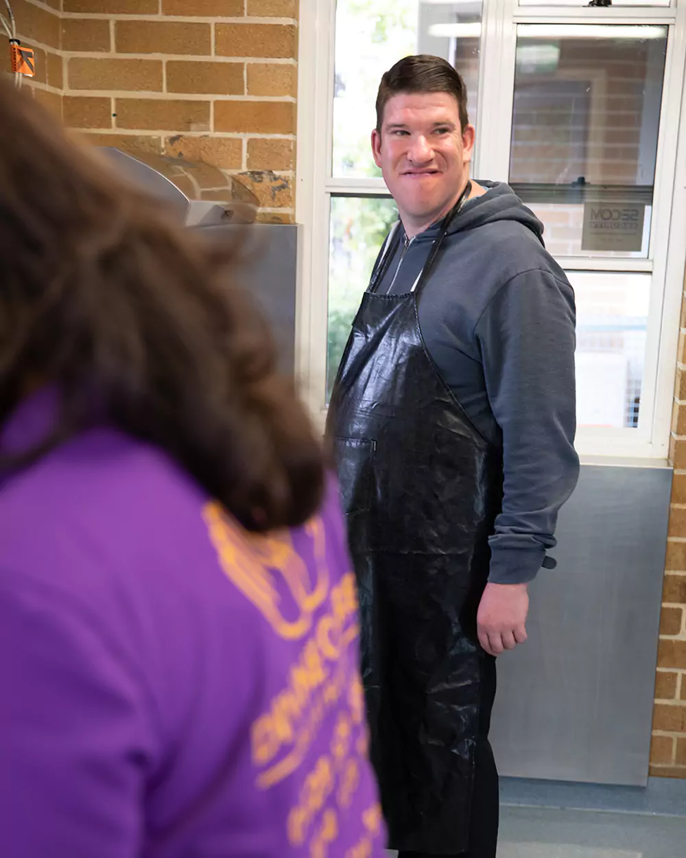 Happy disabled man smiling wearing an apron