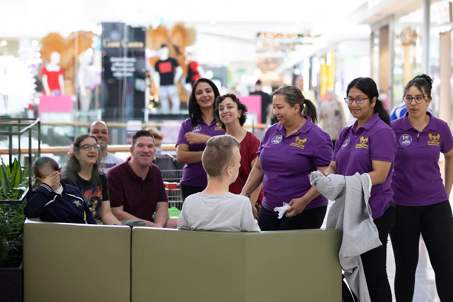 Group of Divine Care Australia support workers in shopping mall with participants